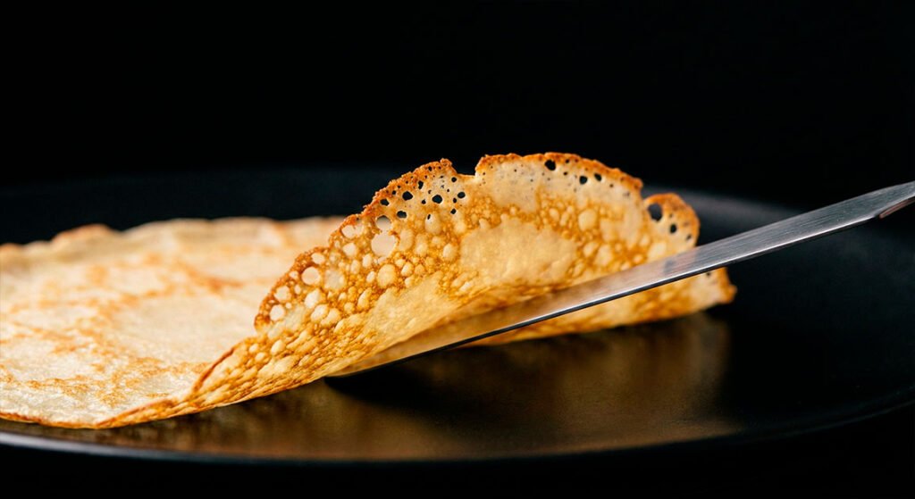 Crepera de 33 cm en uso sobre fondo negro.