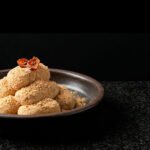 Injeolmi (인절미) Soft rice cakes coated in fine soybean powder, with a minimalist dried persimmon garnish.