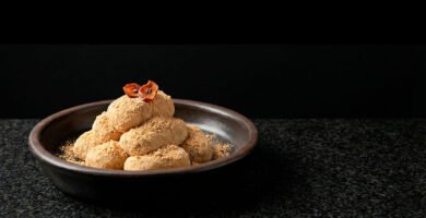 Injeolmi (인절미) Soft rice cakes coated in fine soybean powder, with a minimalist dried persimmon garnish.